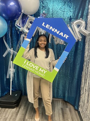 David Lopez and his family Moesha Black take a photo hold a Lennar frame home to celebrate her purchase.