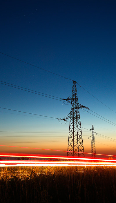Power line tower with the sunrise behind.
