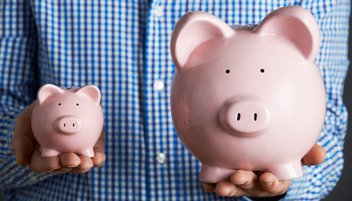 Gentleman holding two different sizes of piggy banks in each hand