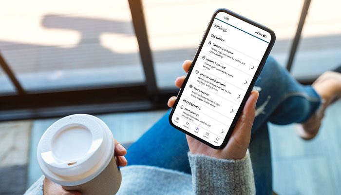 How-to-Protect-Yourself700x400 Female holding a coffee and mobile phone with the First Merchants App Displaying