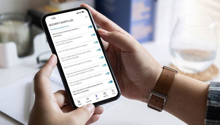How-we-Protect-You700x400 Male holding a mobile phone with the First Merchants App displaying the Security Center